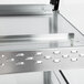 A close-up of a metal shelf with a metal surface on a Hatco countertop hot food display warmer.