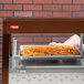 A Hatco countertop food warmer holding a tray of french fries on a shelf.
