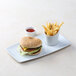 A TuxTrendz white china tray with a cheeseburger and fries on it.