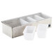 A silver hammered stainless steel condiment bar with five white plastic containers with square bottoms.