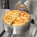 A Nemco commercial waffle maker with a cooked waffle in it.