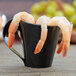 A Fineline black plastic cup filled with shrimp.