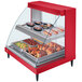 A red Hatco countertop food warmer with glass shelves and a tray of food inside.