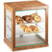 A Cal-Mil bamboo bakery display case with bread and pastries on a counter.