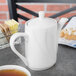 A white Tuxton San Marino AlumaTux teapot on a table.