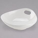 A Tuxton AlumaTux Pearl White china bowl with a handle.