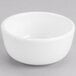 A Tuxton AlumaTux Pearl White soup bowl on a gray surface.