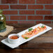 A Tuxton AlumaTux rectangular china plate with shrimp and sauce.
