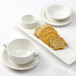 A Tuxton white china rectangular plate with 2 compartments holding bread and a cup.