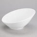 A Tuxton AlumaTux white bowl with a small rim on a gray surface.
