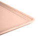 A close-up of a light peach Cambro rectangular dietary tray.