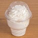 A Fabri-Kal clear plastic dome lid on a plastic cup with white whipped cream inside.