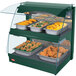 A Hatco Green Glo-Ray double shelf food warmer with trays of food on a table.