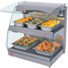 A Hatco countertop food warmer with trays of fried chicken and stuffed peppers.