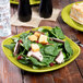 A Fiesta lemongrass square luncheon plate with a salad of spinach, mushrooms, and bacon on it.