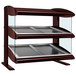 A Hatco slanted double shelf heated zone merchandiser on a counter with glass shelves.