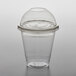 A clear plastic 12 oz. parfait cup with a dome lid on a table.