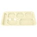 A tan Carlisle polypropylene tray with six compartments of different shapes and sizes.