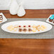 A white 10 Strawberry Street porcelain fish platter on a table with cookies and cupcakes.