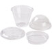 A group of Squat clear plastic parfait cups with Fabri-Kal inserts and lids.