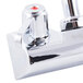 A chrome Equip by T&S wall mounted faucet with 2 red lever handles.