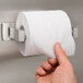 A hand holding a roll of toilet paper.