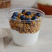 A Solo Ultra Clear plastic squat cup filled with yogurt, granola, and blueberries.