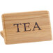 A wooden Cal-Mil bamboo sign with the word "Tea" carved on it.