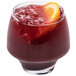 A Chef & Sommelier old fashioned glass of red liquid with an orange slice on top.