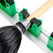 A Unger Hang Up Tool Holder with green clips holding a broom.