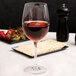 A Chef & Sommelier Cabernet wine glass filled with red wine on a table with strawberries and cheese.