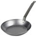 A Vollrath French style carbon steel fry pan with a long metal handle.