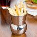 An American Metalcraft Moroccan tumbler filled with french fries on a table.