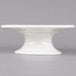 A white porcelain cake stand with a small pedestal on top.