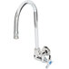 A silver T&S wall mount faucet with a gooseneck spout and 4-arm handle.