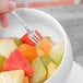 A fork in a 10 Strawberry Street white porcelain angled bowl filled with fruit.