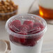 A Solo Ultra Clear PET plastic lid on a cup of yogurt with raspberries.