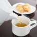 Arcoroc white teapot pouring tea into a white cup.