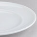 An Arcoroc Rondo bread and butter plate with a white rim on a gray surface.