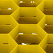 A yellow rectangular Vollrath glass rack with a hexagonal grid.
