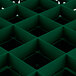 A green plastic grid with square compartments and holes.