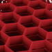 A red plastic container with hexagons and holes holding 30 glasses.