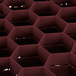A close up of a red hexagonal grid with a black rectangular object.