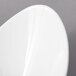 A close-up of a 10 Strawberry Street Whittier white porcelain cradle bowl with a curved edge.