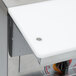 A white metal counter with a white APW Wyott steam table on top.