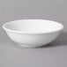 A 10 Strawberry Street Whittier white porcelain sauce dish on a gray surface.