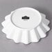 A white porcelain bowl with a scalloped edge.