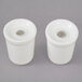 A pair of white porcelain salt and pepper containers with lids.