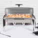 A Vollrath stainless steel chafer filled with shrimp and vegetables on a table.