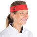 A woman wearing a red Headsweats headband in a professional kitchen.